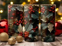 two christmas themed glasses sitting next to each other on a table with ornaments and lights in the background