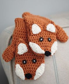 two crocheted foxes are sitting on the back of a chair