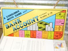 a bank account game sitting on top of a table next to a piece of paper