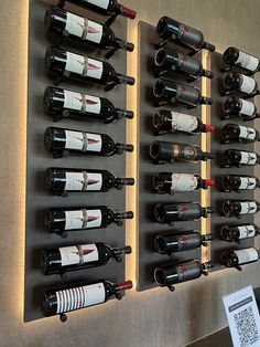 several wine bottles are lined up on the wall