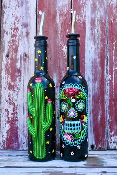 two bottles with painted designs on them sitting next to each other