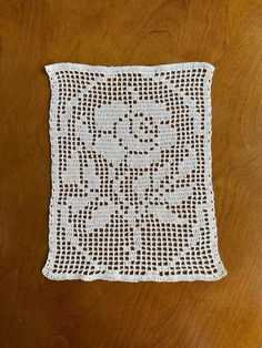 a white crocheted doily sitting on top of a wooden table