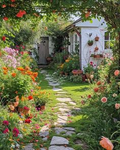 a garden with lots of flowers and plants in the front yard, along with a path leading to a small white building