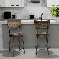 two bar stools sitting next to each other in front of a kitchen counter top