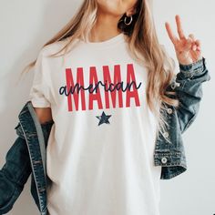 ORDER BY DECEMBER 10TH TO ENSURE CHRISTMAS DELIVERY.  ORDERS WILL STILL BE ACCEPTED AFTER THIS DATE, AND WILL BE PROCESSED AS SOON AS POSSIBLE, BUT MAY NOT ARRIVE BEFORE CHRISTMAS DAY.  PLEASE PLAN ACCORDINGLY AS REFUNDS WILL NOT BE PROVIDED FOR ORDERS THAT ARE DELIVERED WITHIN THIER ESTIMATED WINDOW.   Stay on trend this 4th of July with this American Mama Comfort Colors® t-shirt. The combination of stars, and the patriotic red/white/blue color scheme make this Independence Day tee perfect for Americana Cotton T-shirt With Letter Print, 4th Of July Cotton T-shirt With Text Print, White Americana Letter Print T-shirt, Memorial Day Cotton Crew Neck T-shirt, White American Style Tops For Memorial Day, White Americana T-shirt For 4th Of July, American Style Cotton T-shirt With Short Sleeves, American Flag Cotton T-shirt For 4th Of July, American Style Cotton Tops With Flag Print