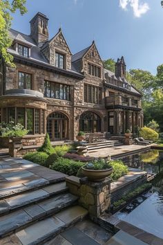 a large stone house with lots of windows and steps leading up to the front door