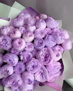 a bouquet of purple flowers sitting on top of a table