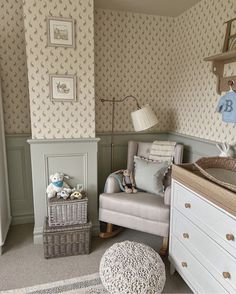 a baby's room with a crib, chair and dresser