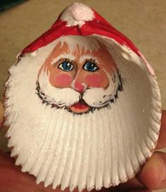 a close up of a person's hand holding a small plastic santa claus head