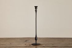 a black candle holder sitting on top of a wooden table