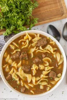 a white bowl filled with pasta and meat soup