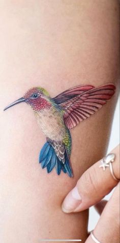 a small hummingbird tattoo on the thigh