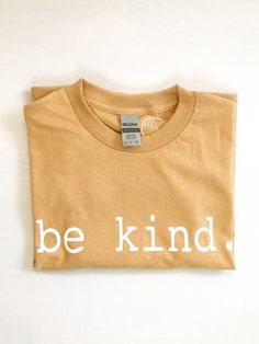 Be Kind T Shirt You won't be disappointed with the quality of this graphic tee with its comfortable fit! This is a 100% cotton shirt with a white screen print transfer design. Color: Old Gold Brand: Gildan Shirt is unisex so fit is more loose and relaxed, but otherwise fits true to size. CARE INSTRUCTIONS -Wash inside out -Tumble dry low -Avoid direct heat to design *Order includes one short sleeve tee Be Kind T Shirt, White Screen, Screen Print Transfer, Print Transfer, Inspirational Tees, Spread Kindness, Gold Branding, Design Color, Be Kind