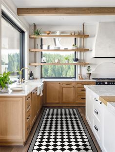 a kitchen with black and white checkered flooring next to a stove top oven