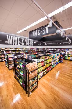 a store filled with lots of bottles of wine and beer next to wooden flooring