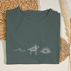 a t - shirt with a drawing of a turtle swimming in the ocean on it