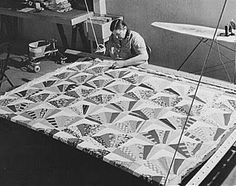 an old black and white photo of a woman working on a quilt