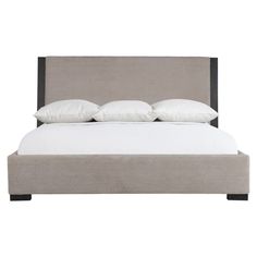 an upholstered bed with four pillows and two white pillows on the headboard