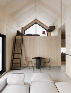 a living room filled with furniture next to a loft style window and wooden ceilinging