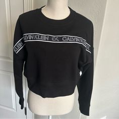 Nwt Black Calvin Klein Women’s Logo Cropped Pullover Size M Long Sleeves. Trendy Black Calvin Klein Tops, Calvin Klein Crew Neck Sweatshirt With Ribbed Cuffs, Calvin Klein Black Long Sleeve Tops, Trendy Calvin Klein Fall Tops, Trendy Calvin Klein Tops For Fall, Trendy Calvin Klein Top For Fall, Calvin Klein Sporty Black Top, Sporty Black Calvin Klein Tops, Calvin Klein Black Winter Tops