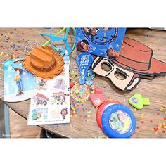 a table topped with toys and confetti on top of it's wooden surface