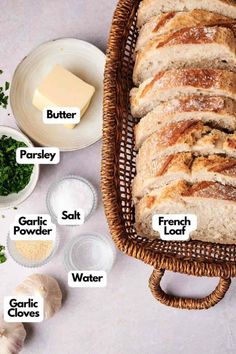 bread in a wicker basket next to garlic, butter, parsley and salt