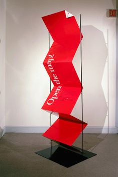 a red display case sitting in the middle of a room next to a white wall