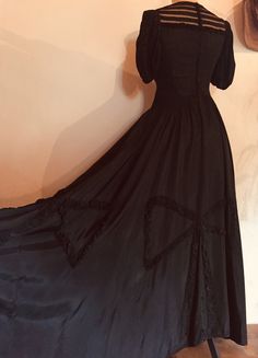 "This beautifully made 1930s silky rayon dress is rich with detail and workmanship.  It has full puffed sleeves, gathered around the bicep, and across the front and back yoke it has a silk tulle with slim strips of the rayon body fabric, creating a partially see-through area.  The dress undoes via a long row of covered buttons down the centre back. The skirted section of the dress is full length and very full, with appliquéd large bows around the hemline, made from the tightly ruched silky rayon fabric. ------------------------------------------------ Measurements: Bust at underarm: 34\" Waist: 28\" Hips: free Length from centre front neck to hem: 55½\" Condition: generally excellent, with some 'grinning' to the vertical seams on the waist and bust. ---------------------------------------- Vintage Satin Victorian Costume Dress, Vintage Victorian Satin Costume Dress, Vintage Victorian Satin Dress For Costume, Vintage Satin Victorian Dress For Costume, Vintage Victorian Dress With Fitted Bodice For Evening, Vintage Victorian Satin Dress For Formal Occasions, Vintage Satin Victorian Dress For Formal Occasions, Formal Vintage Victorian Satin Dress, Vintage Solid Color Formal Dress