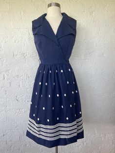 Adorable vintage navy polka-dot retro style wrap dress with single button closure at bust. The brand is Rosani San Francisco. Feels like cotton. Dress is lined.  Flaws: The wrap tie is not included. hook and eye are missing to secure the front of the dress. Some of the hem is coming undone. There are several areas of pilling and loose threads from the polka dots.  Measurements: Bust: 18.5" Waist: 14"-16" (adjustable) Hips: free Length: 39" Polka Dot Dress Vintage Button Down Back, Retro Navy Dress For Spring, Navy Retro Summer Dress, Style Wrap Dress, 60s Mod, 1950s Fashion, Vintage 60s, Dress Clothes For Women, Cotton Dress