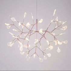 a chandelier with lights hanging from it's branches in the shape of a snowflake