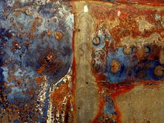 rusted metal with blue and red paint on the outside, in an area that looks like it could be used as a background