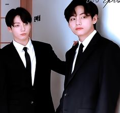 two young men in suits and ties posing for the camera with their arms around each other