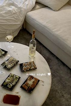 a table topped with plates of food next to a bottle of wine