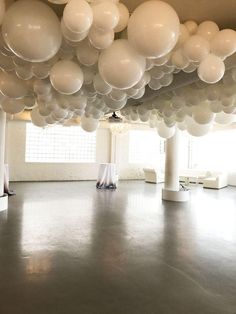 an empty room with white balloons hanging from the ceiling