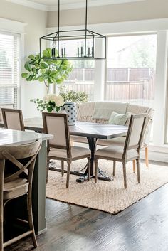 a dining room table with chairs and a rug on the floor in front of it