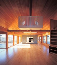 an empty room with wooden floors and open windows