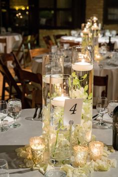 the table is set with candles, flowers and place cards for guests to sit at