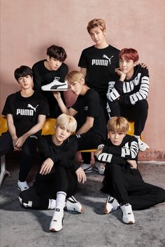 the group of young men are posing together for a photo in black and white outfits