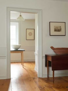 an empty room with wooden floors and white walls