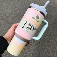 a person holding a pastel colored tumbler cup