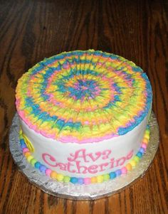 a birthday cake decorated with colorful icing on a wooden table