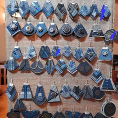 there is a display of earrings on the wall in front of a table with other items