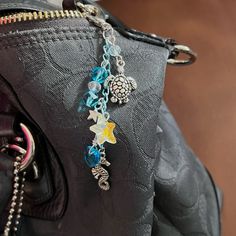 a purse with charms hanging from it's side