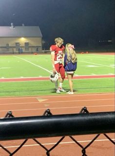 two girls standing on a football field at night