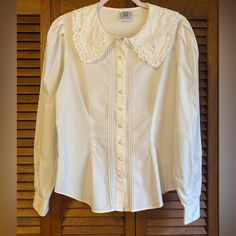 Vintage Laura Ashley Blouse Made In Hong Kong When It Was Still A British Colony Lace Detail, Pintucking, Covered Buttons, Puff Sleeves, Embroidery. Lightweight 100% Cotton. Vintage Size Us 10 / Uk 14 / Eur 40 Chest About 21” Across Sleeves About 24 1/2” Waist About 17” Excellent Pre-Owned Vintage Condition With No Obvious Rips, Tears Or Stains. Tags: Vintage, Victorian Edwardian, Coquette. Homestead, Cosplay Classic Fitted Blouse With Peter Pan Collar, Classic Fitted Blouse With Lace Collar, Fitted Collared Blouse With Lace Collar, Fitted Blouse With Lace Collar, Feminine Fitted Blouse With Peter Pan Collar, Classic Puff Sleeve Blouse With Lace Trim, Classic Blouse With Lace Trim And Puff Sleeves, Ashley White, Sleeves Embroidery