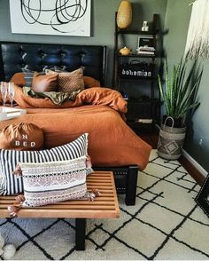 a bed room with a neatly made bed and some pillows on the end table next to it