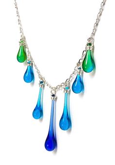 Seven handmade glass droplets drip from a twisted chain of sparkling silver in this exquisite necklace design. Colors vary - you are welcome to request a color palette. Droplet lengths: 3/4" - 1 1/4" (1.9 - 3.2 cm) Chain length: 16" to 18.5" - a 16" recycled sterling silver twist chain with 2.5" inch extender allows adjustment to fit your style and outfit Eco−friendly jewelry, made from sun−melted recycled bottles and stained glass, finished with recycled silver Recycled sterling silver findings Teardrop Party Necklace With Chain, Elegant Glass Drop Jewelry, Elegant Drop Glass Jewelry, Elegant Drop-shaped Glass Jewelry, Sterling Silver Teardrop Chain Jewelry, Party Drop Necklace With Adjustable Chain, Wire Wrapped Drop Jewelry For Party, Silver Drop Crystal Necklace With Adjustable Chain, Silver Teardrop Czech Glass Jewelry