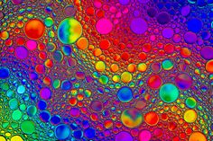 multicolored bubbles are floating in the air, creating an interesting pattern on this colorful background