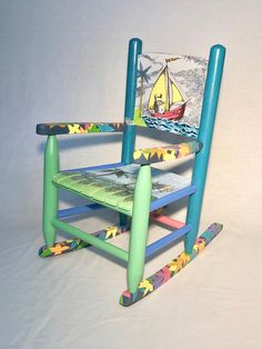 a child's rocking chair made out of plastic and painted with an image of a sailboat