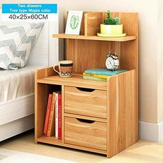 a wooden shelf with two drawers and a clock on it in front of a bed